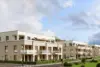 Moderne Wohnanlage mit mehrgeschossigen Gebäuden, Balkonen und Grünflächen in zeitgenössischer Architektur