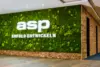 Mooswand mit ASP Logo und Slogan "Erfolg entwickeln" in modernem Büroempfang mit Holzelementen