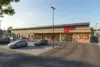 Moderner REWE Supermarkt mit Bäckerei, Parkplatz und Kunden am Eingang bei Tageslicht
