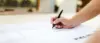 Hand zeichnet mit schwarzem Stift auf Architekturplan oder technischer Zeichnung auf hellem Papier